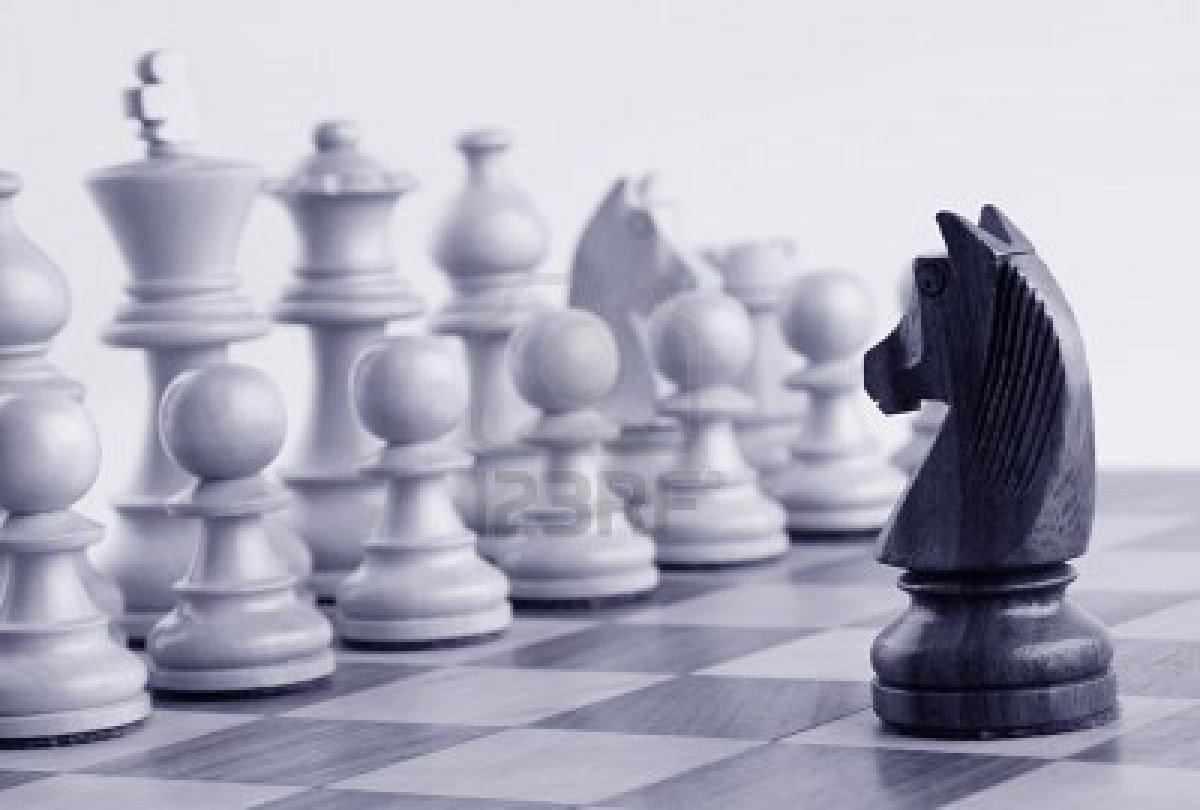 10205685-black-knight-facing-white-chess-pieces-on-a-chess-board